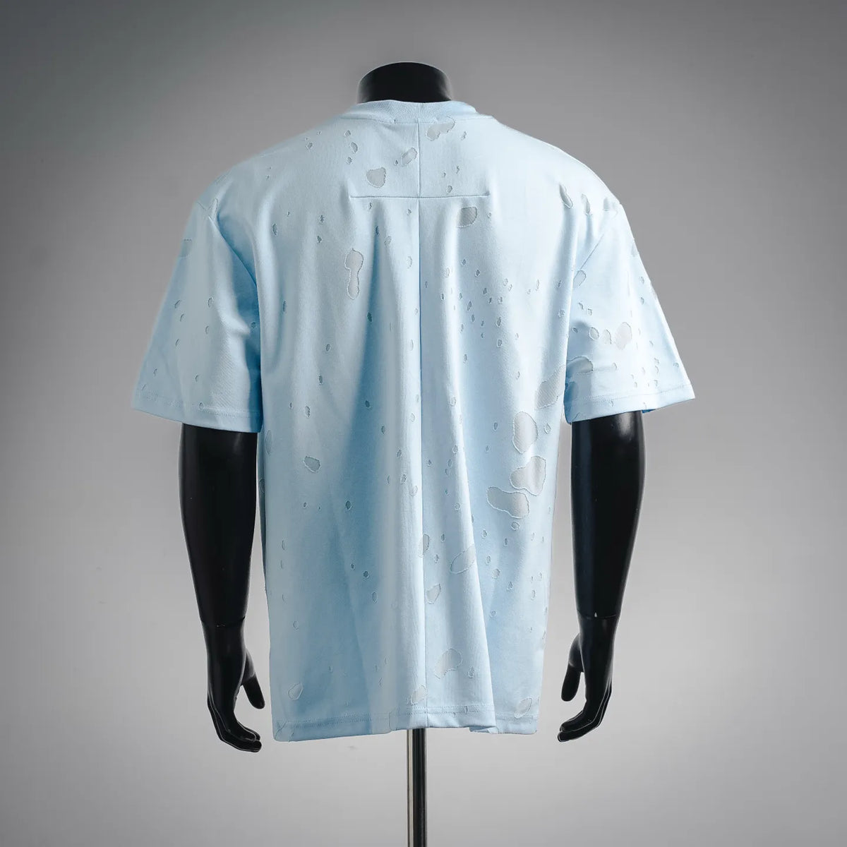 Light blue short-sleeve T-shirt, back view with scattered logo-style marks