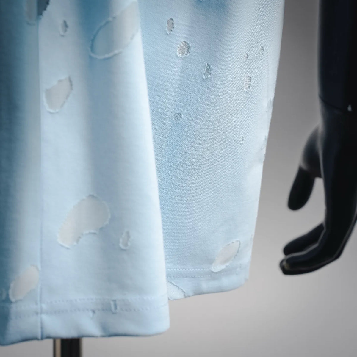 Light blue short-sleeve T-shirt hem with raised pattern texture detail