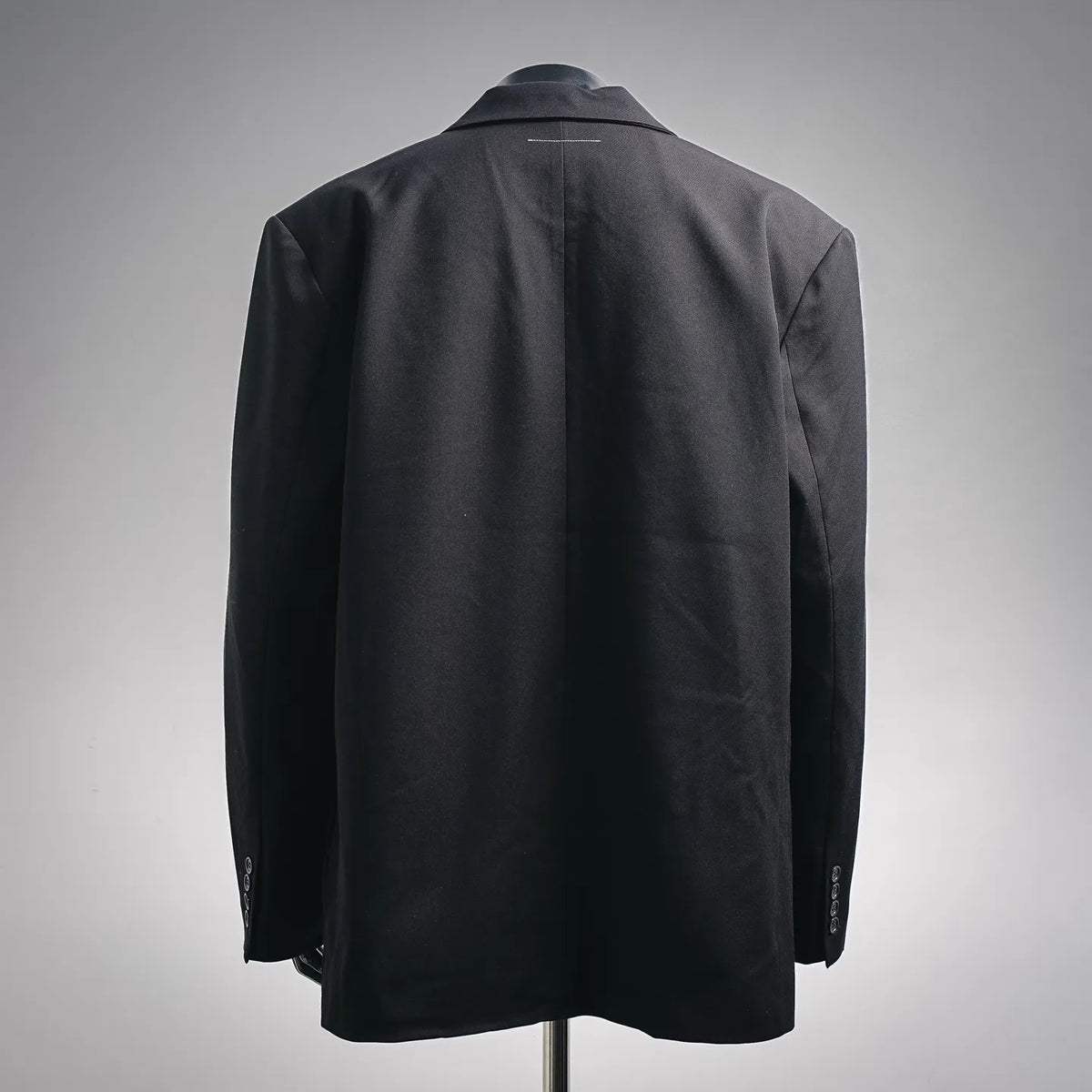 Dark black coat back view with shoulder seams and center back paneling