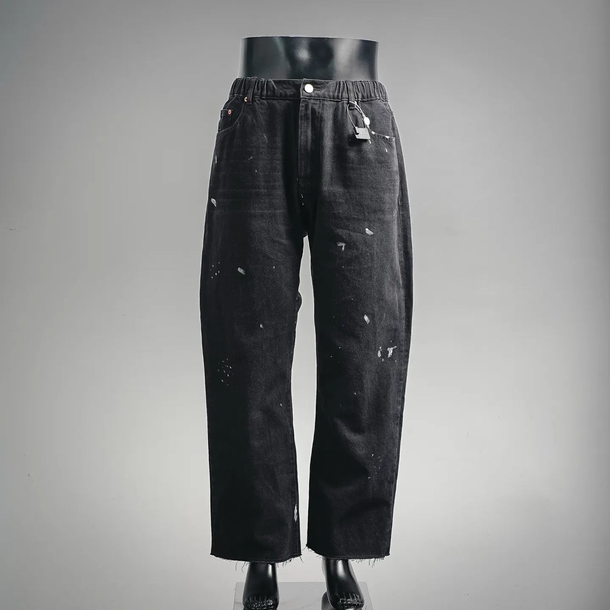 Black denim pants with elastic waistband and relaxed straight legs; button fly detail.