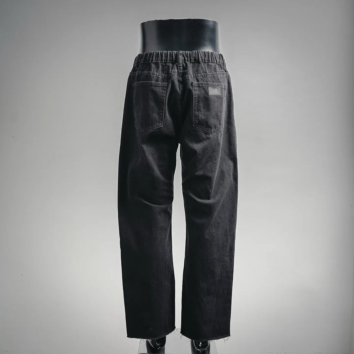 Black denim pants with gathered elastic waistband and full-length relaxed legs.