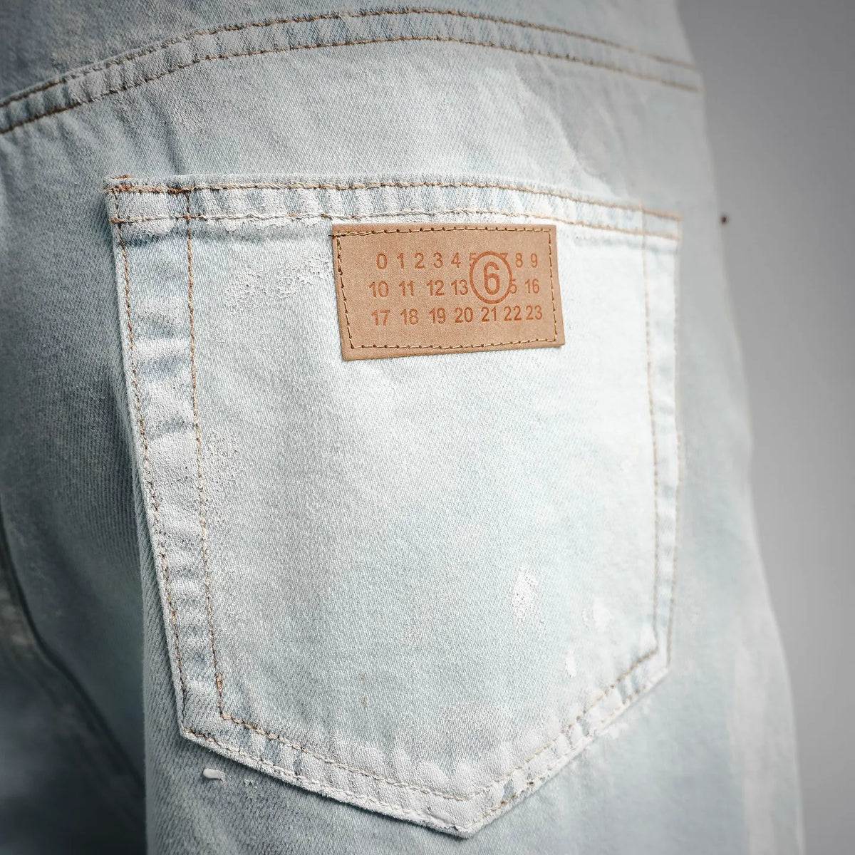 Light blue denim pants with leather patch label on back pocket