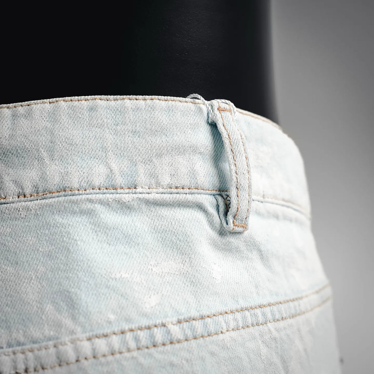 Light blue denim pants waistband with belt loops and button closure