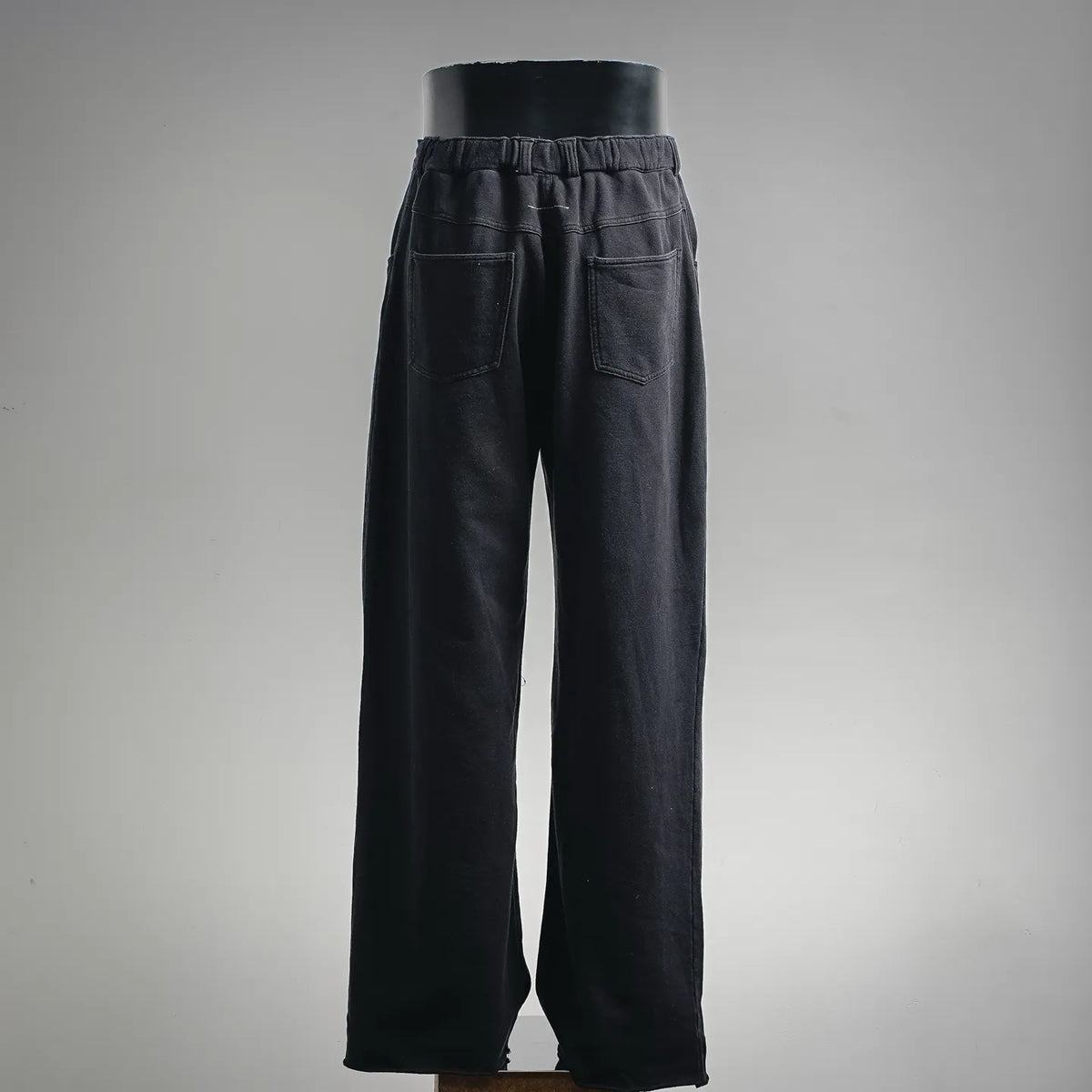 Black relaxed-fit pants with elastic waistband and two back patch pockets