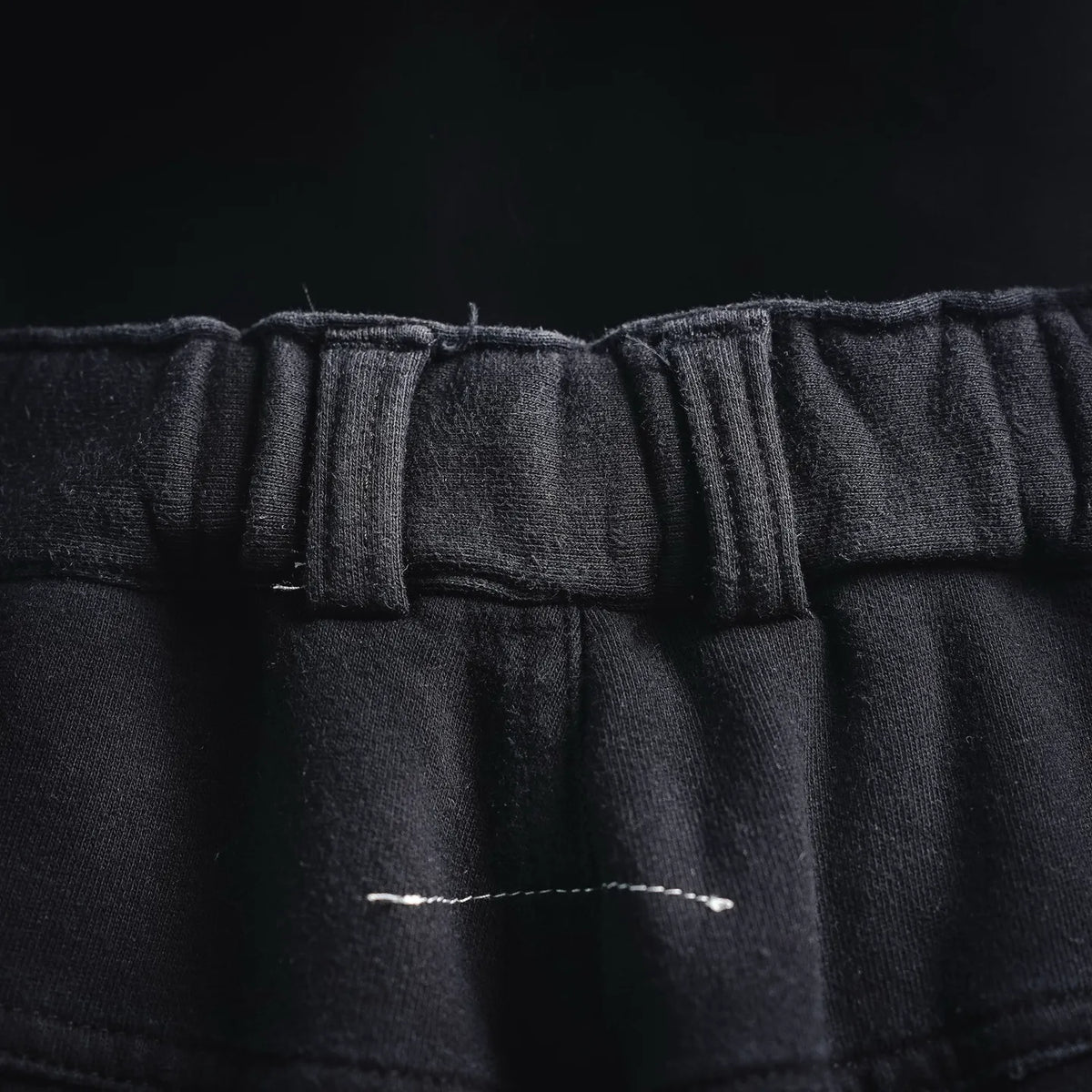 Close-up of black waistband with gathered elastic and visible seam stitching