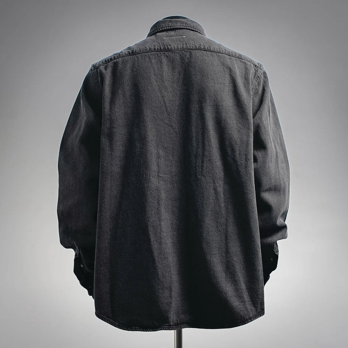 Black denim long-sleeve shirt back view with yoke seam and curved hem