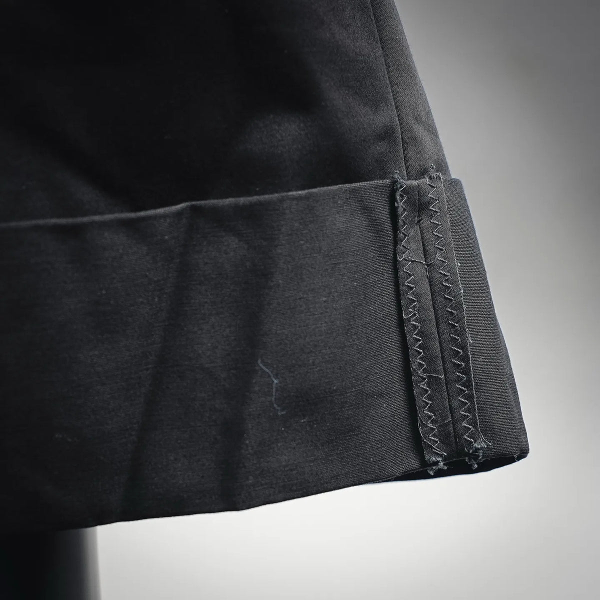 Black fabric hem with zigzag stitch detail.