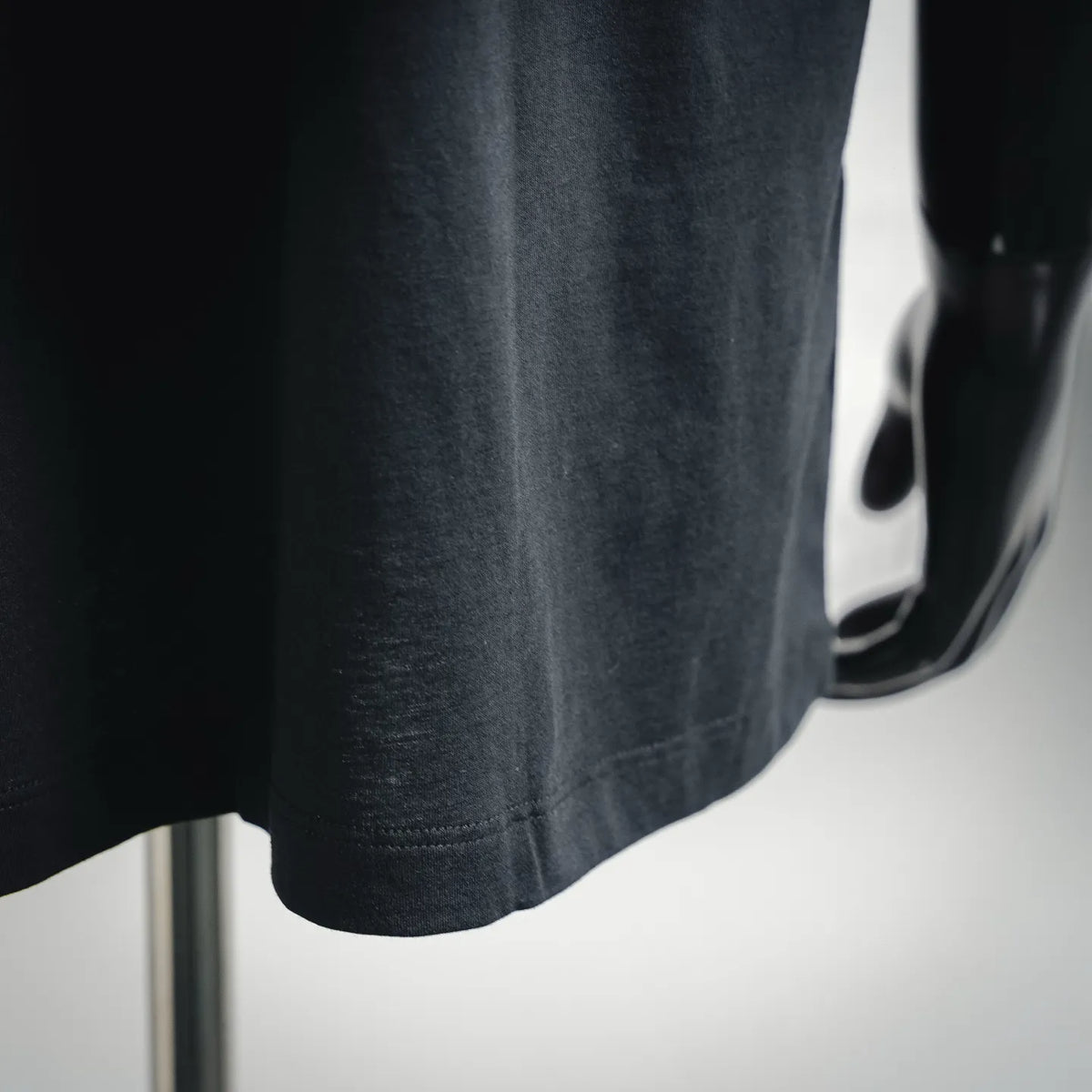 Dark T-shirt hem and fabric texture close-up
