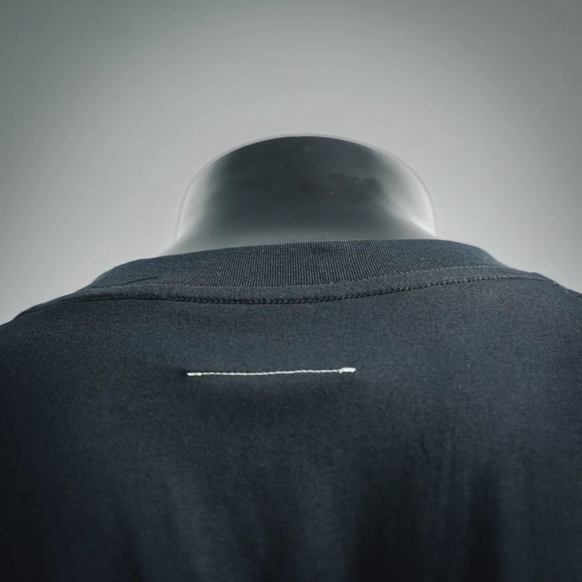 Dark T-shirt back yoke with small embroidered detail line