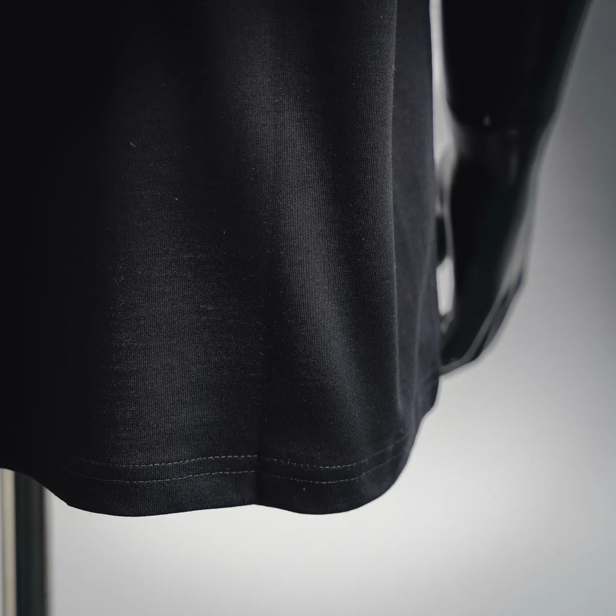 Black T-shirt fabric and straight hem with visible stitching