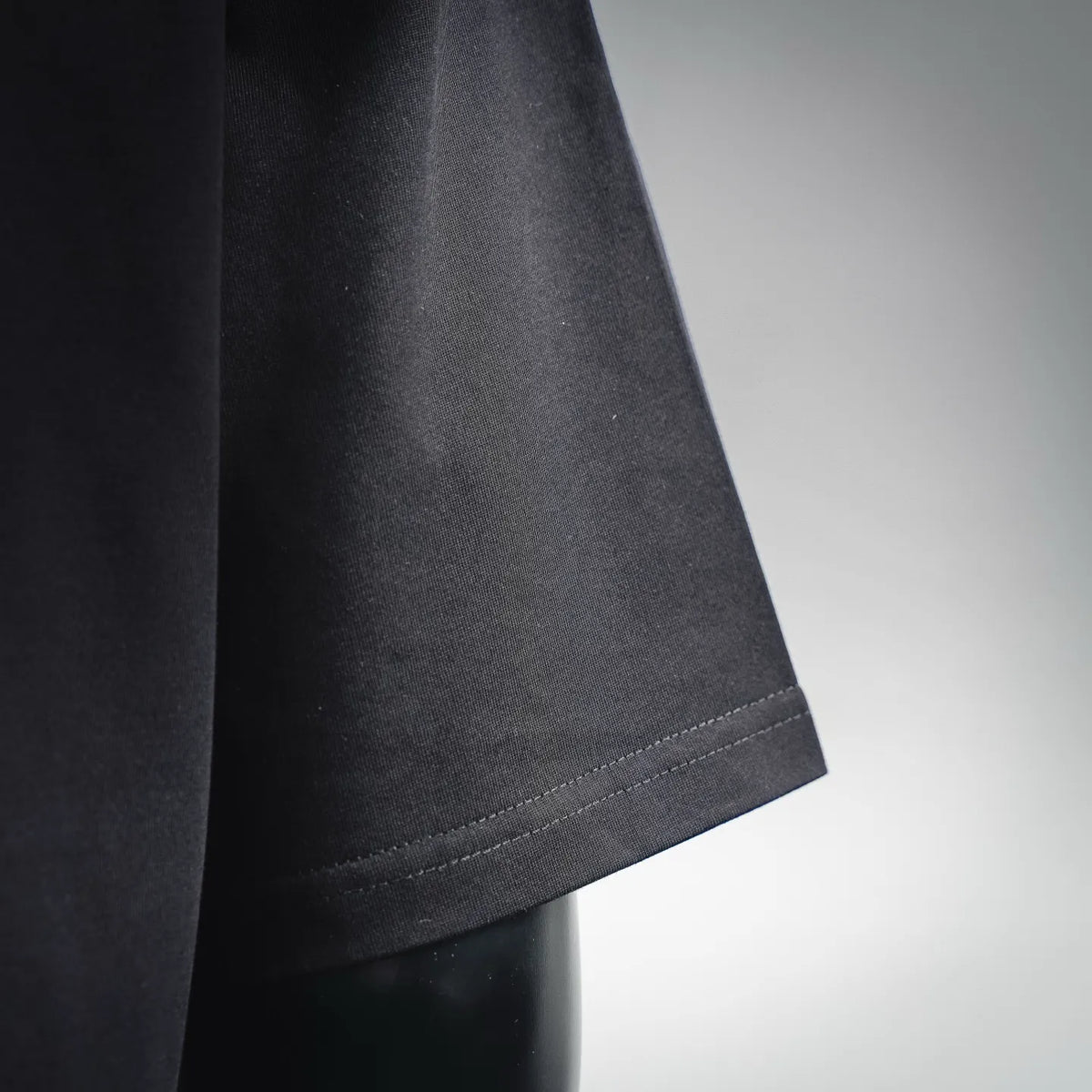 Black T-shirt sleeve cuff and hem stitch detail