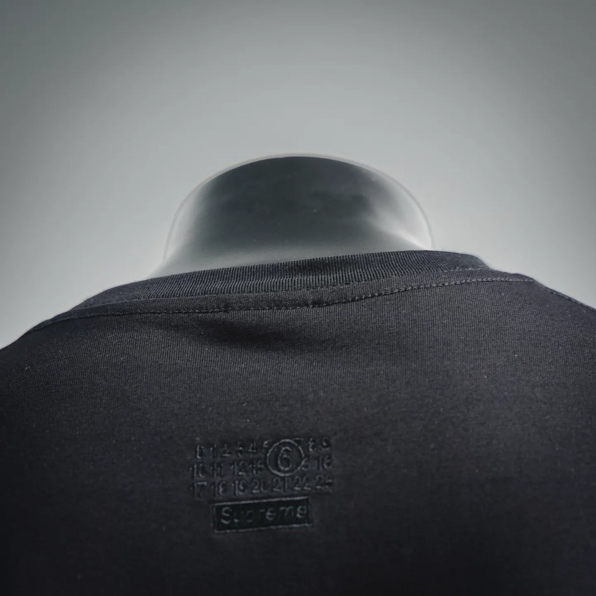 Black T-shirt neck tag area with small brand print on back