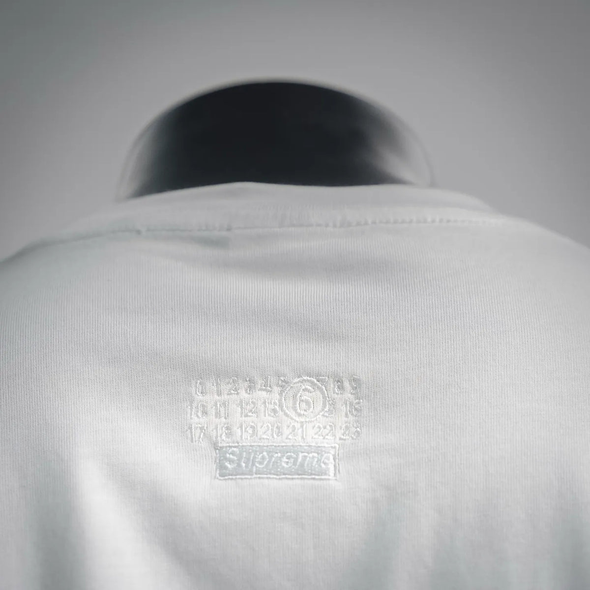 White T-shirt back close-up with small printed logo near collar