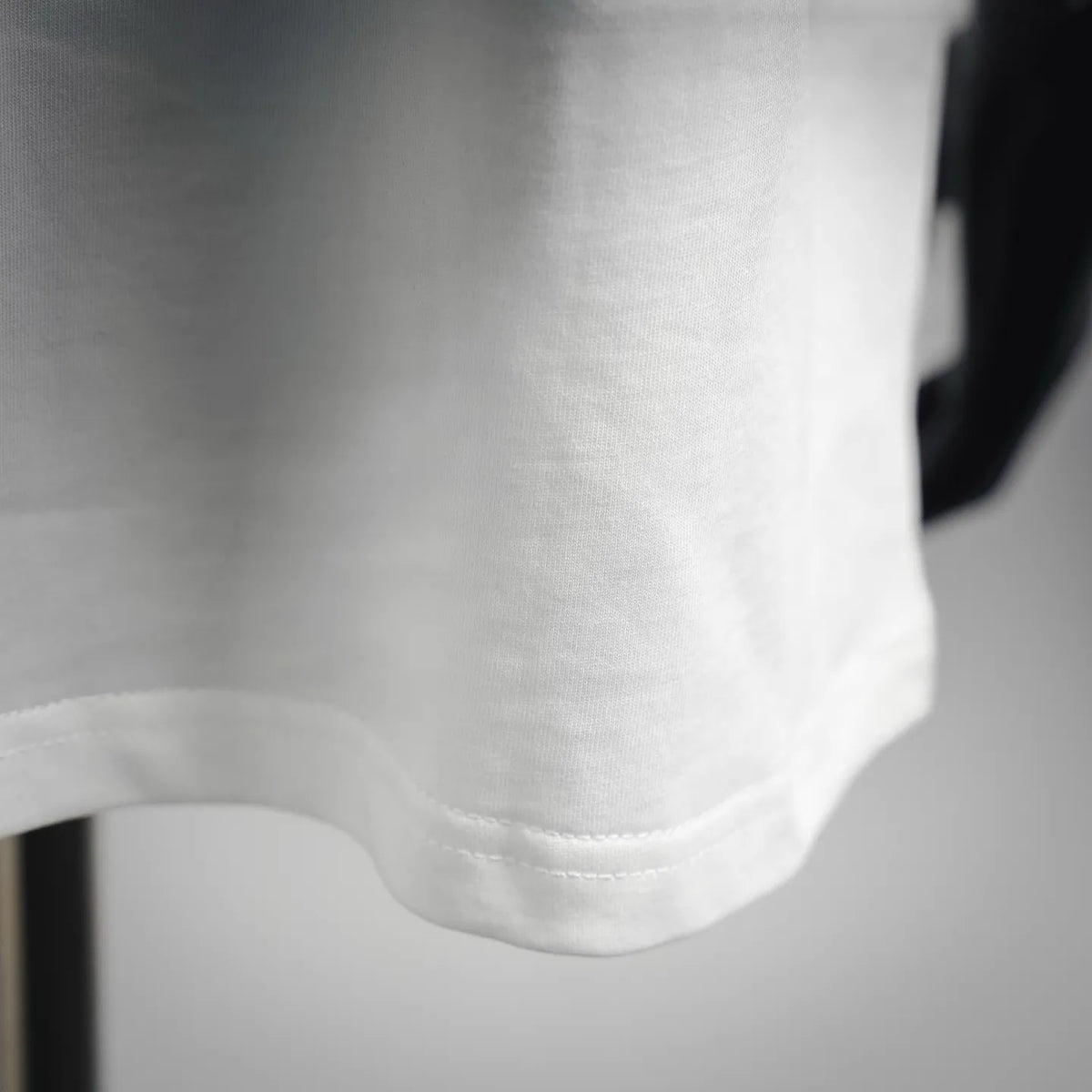 White T-shirt sleeve hem close-up with stitched cuff detail