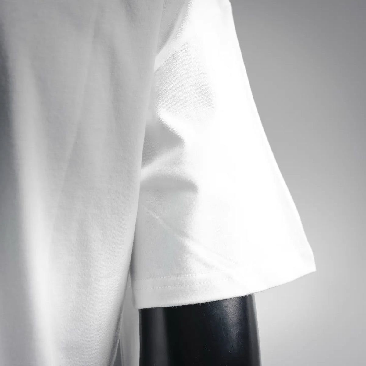 White short-sleeve T-shirt sleeve and side hem seam close-up