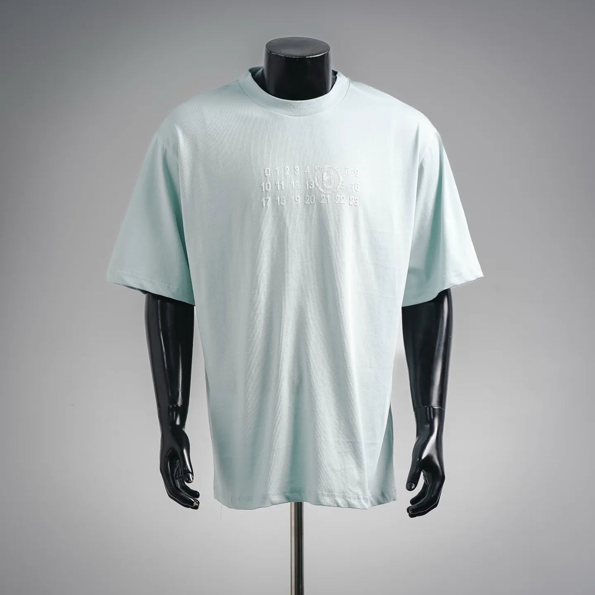Light blue crew-neck T-shirt with short sleeves and small front number graphic