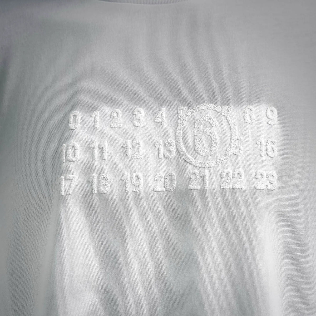 White T-shirt with raised numeric graphic and outlined circular logo