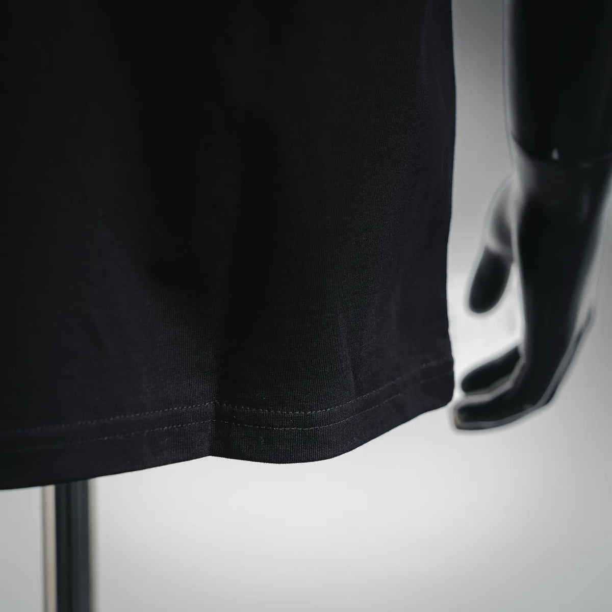 Black short-sleeve T-shirt hem with stitched bottom and smooth fabric