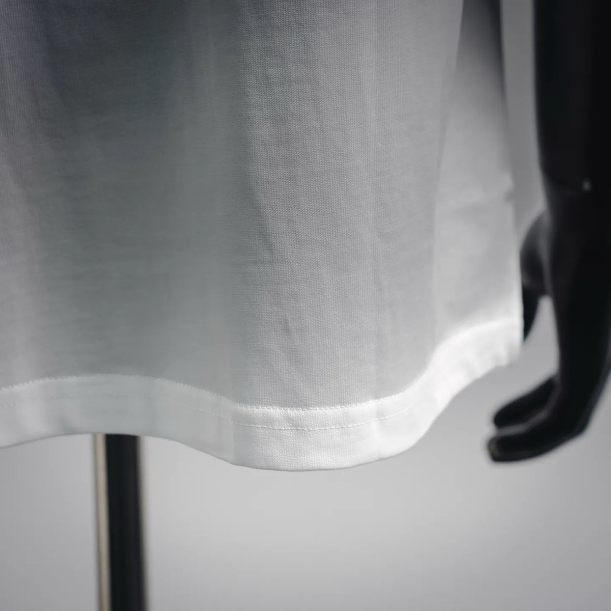 Men's white T-shirt hem with stitched bottom seam