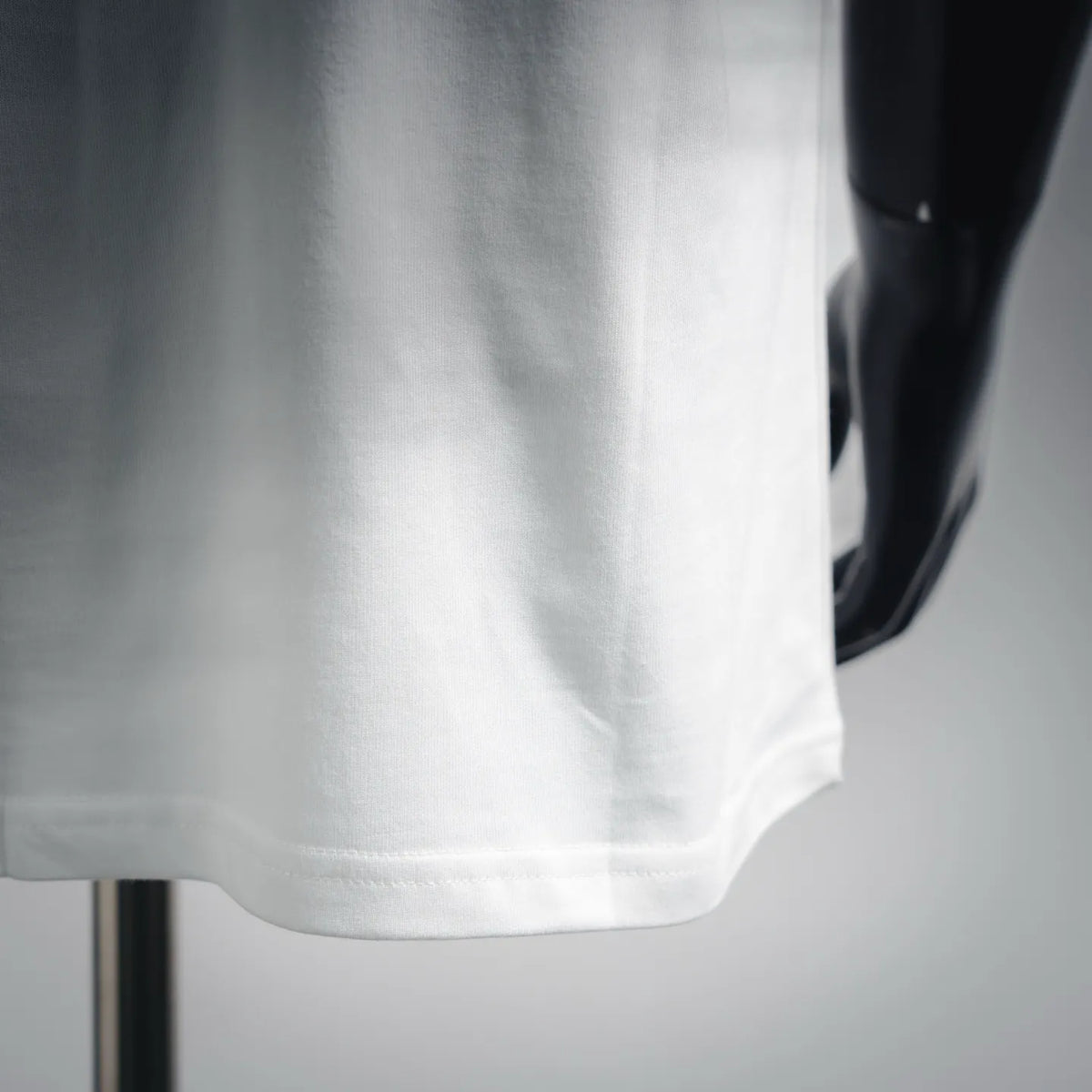 White T-shirt hem and side seam detail with short-sleeve cut