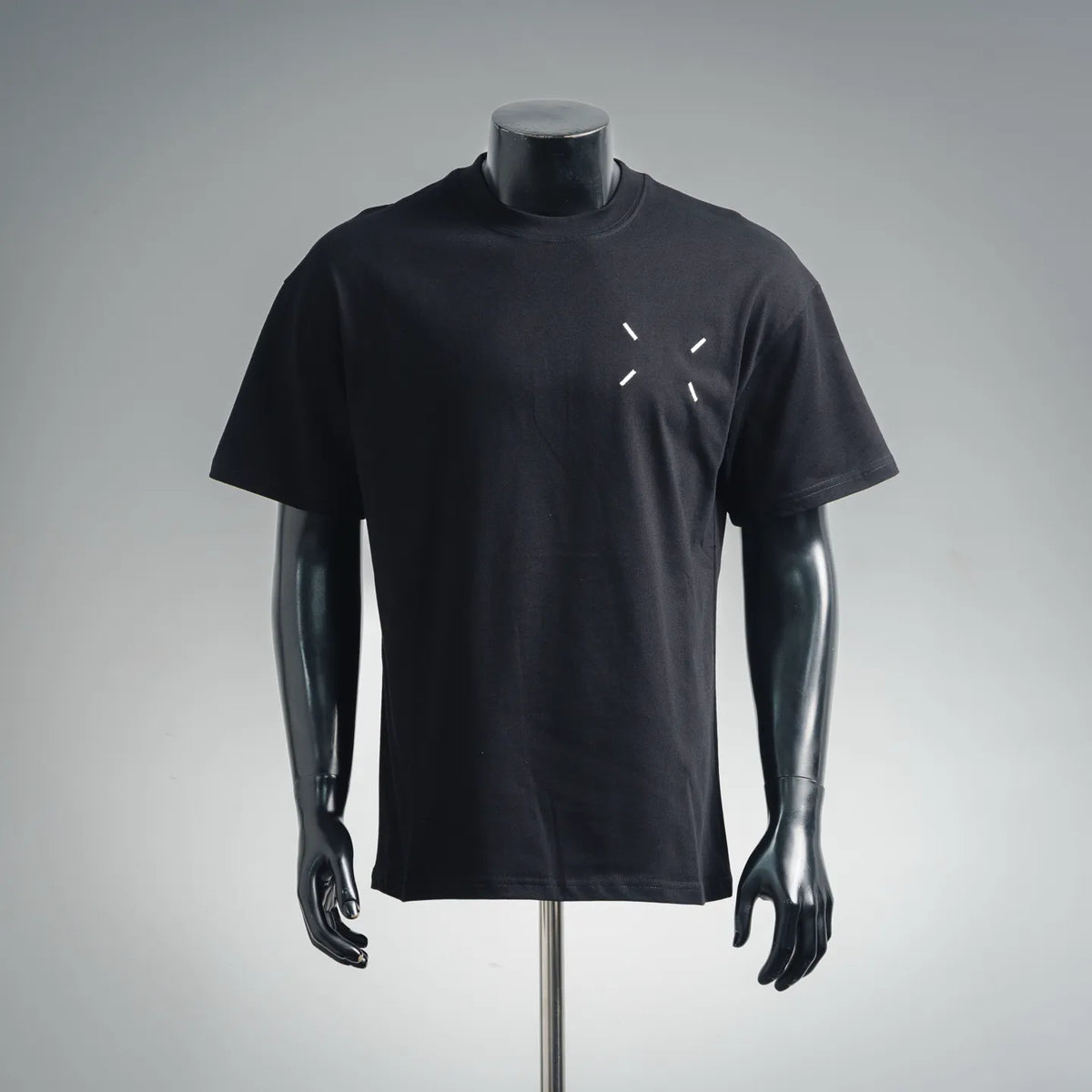 Black short-sleeve t-shirt with small diagonal white graphic detail at chest