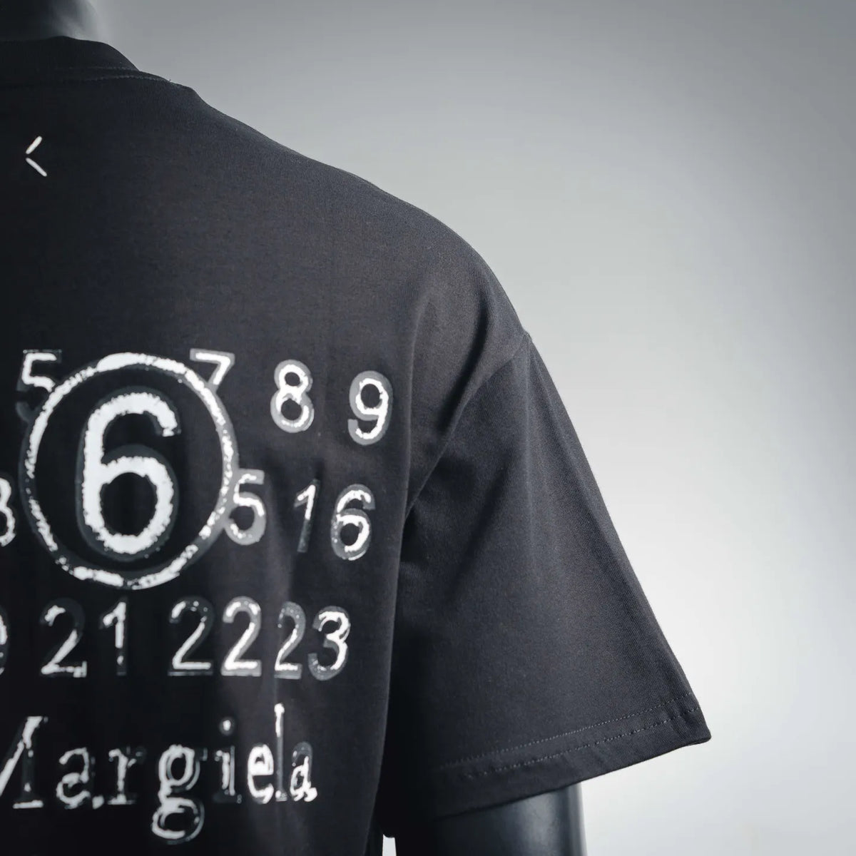 Black short-sleeve t-shirt sleeve with partial '6' numeric graphic print