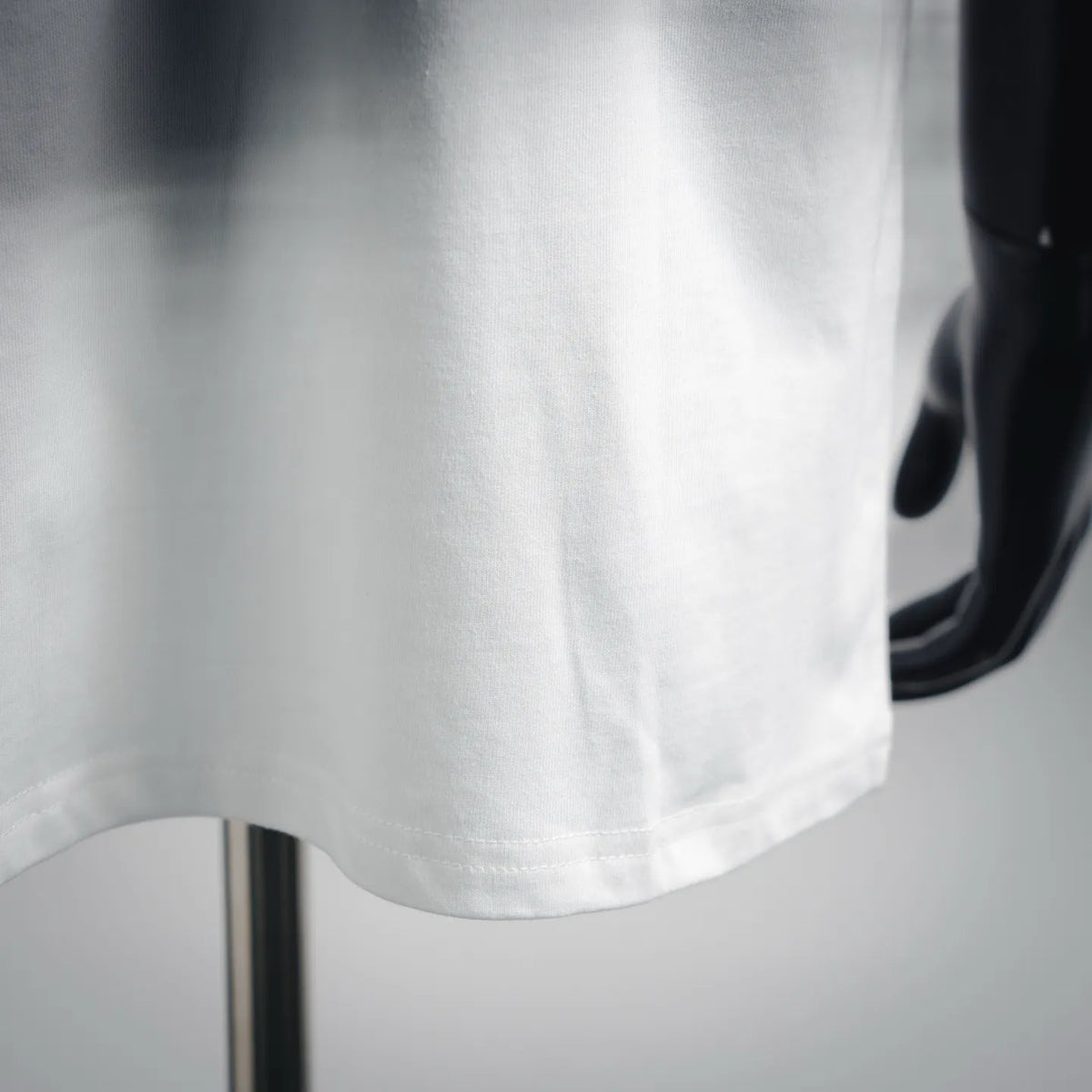 White T-shirt sleeve and lower hem with visible seam stitching