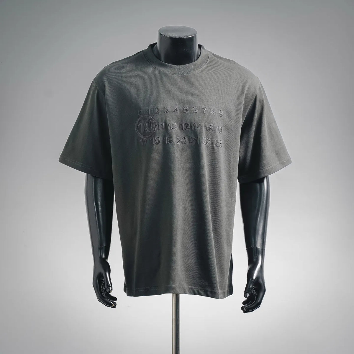 Dark gray crew-neck T-shirt with embossed circular logo and number graphic at chest