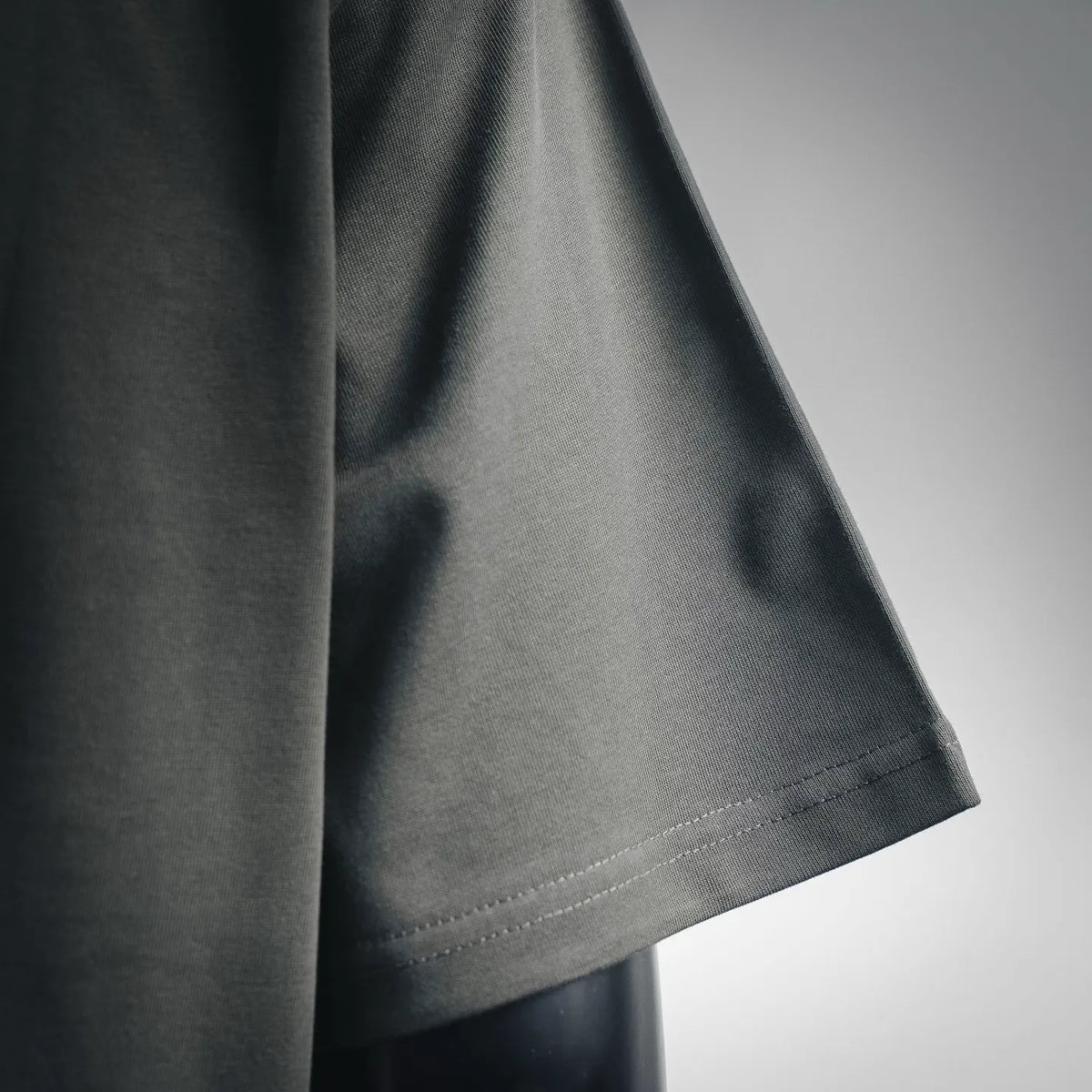 Dark gray T-shirt sleeve and side hem with neat stitching seam