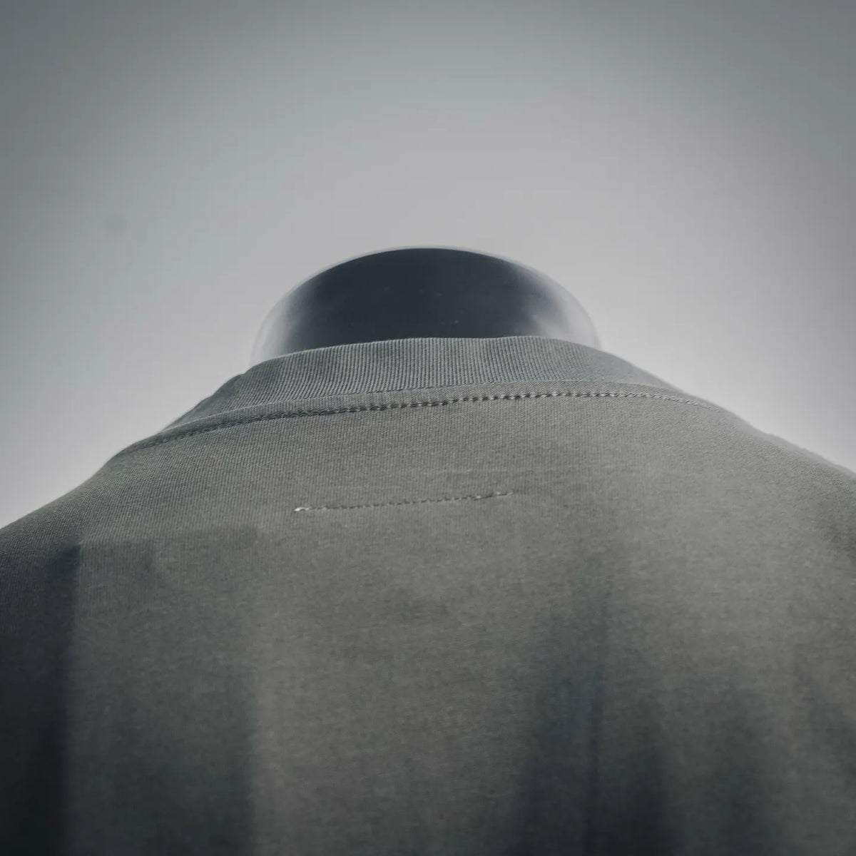 Dark gray crew-neck T-shirt collar and back yoke with stitched neckline