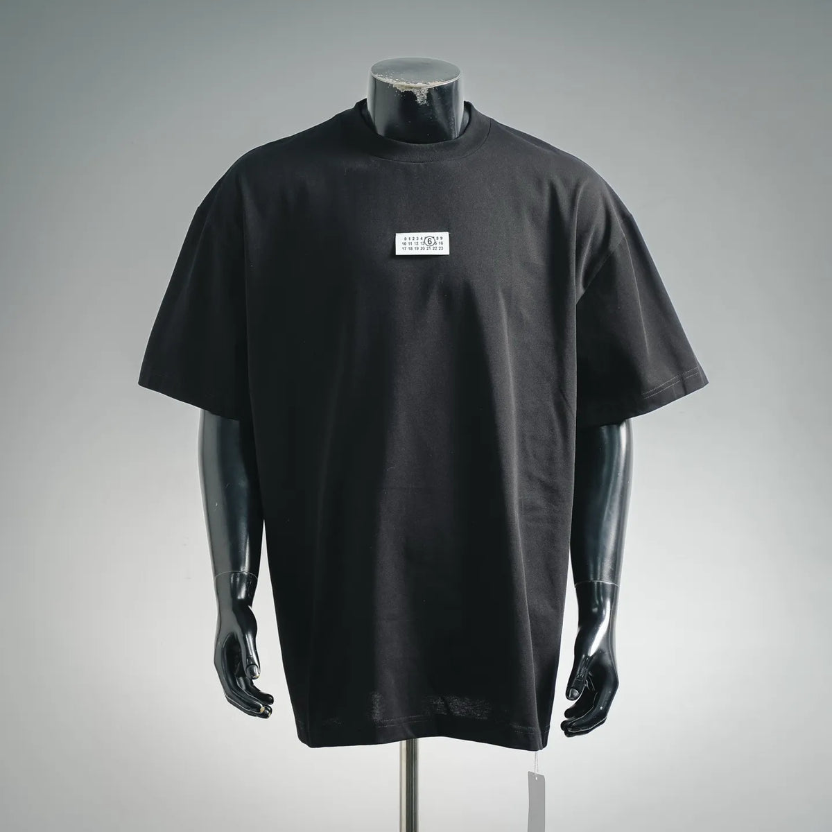Black short-sleeve crewneck T-shirt on mannequin, small chest label.