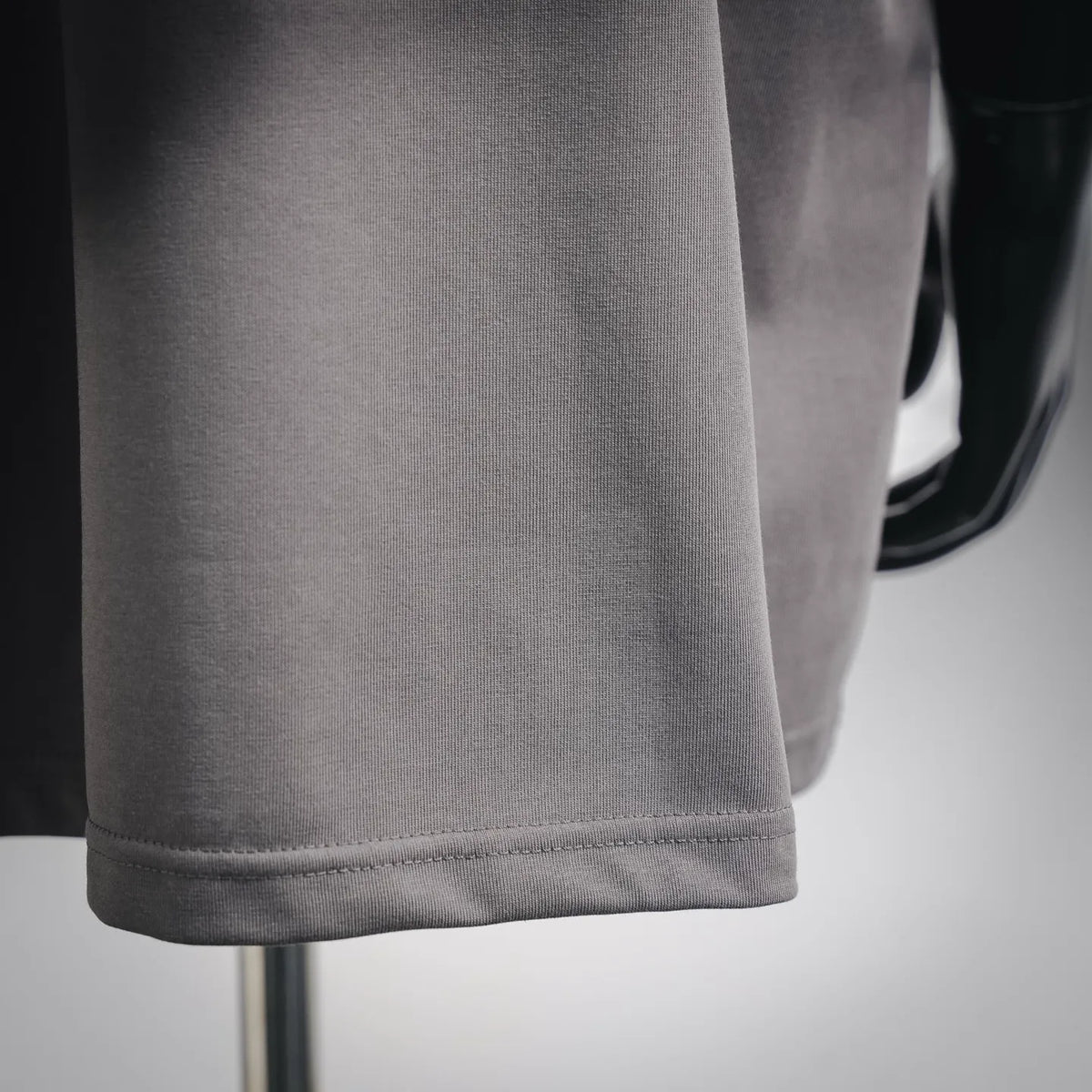 Gray T-shirt hem with straight stitching and clean finished edge