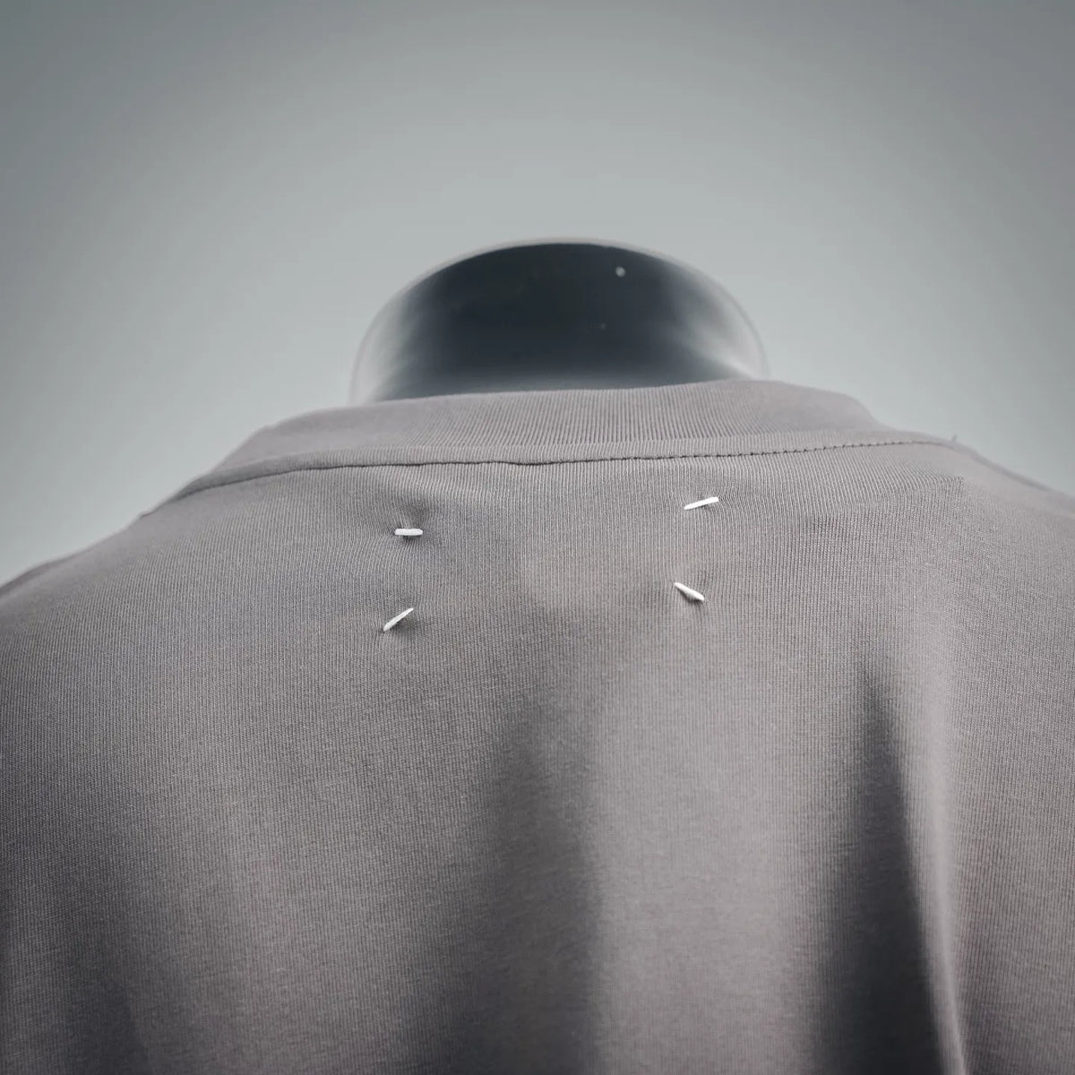 Gray T-shirt back with small metallic stud detailing near shoulders