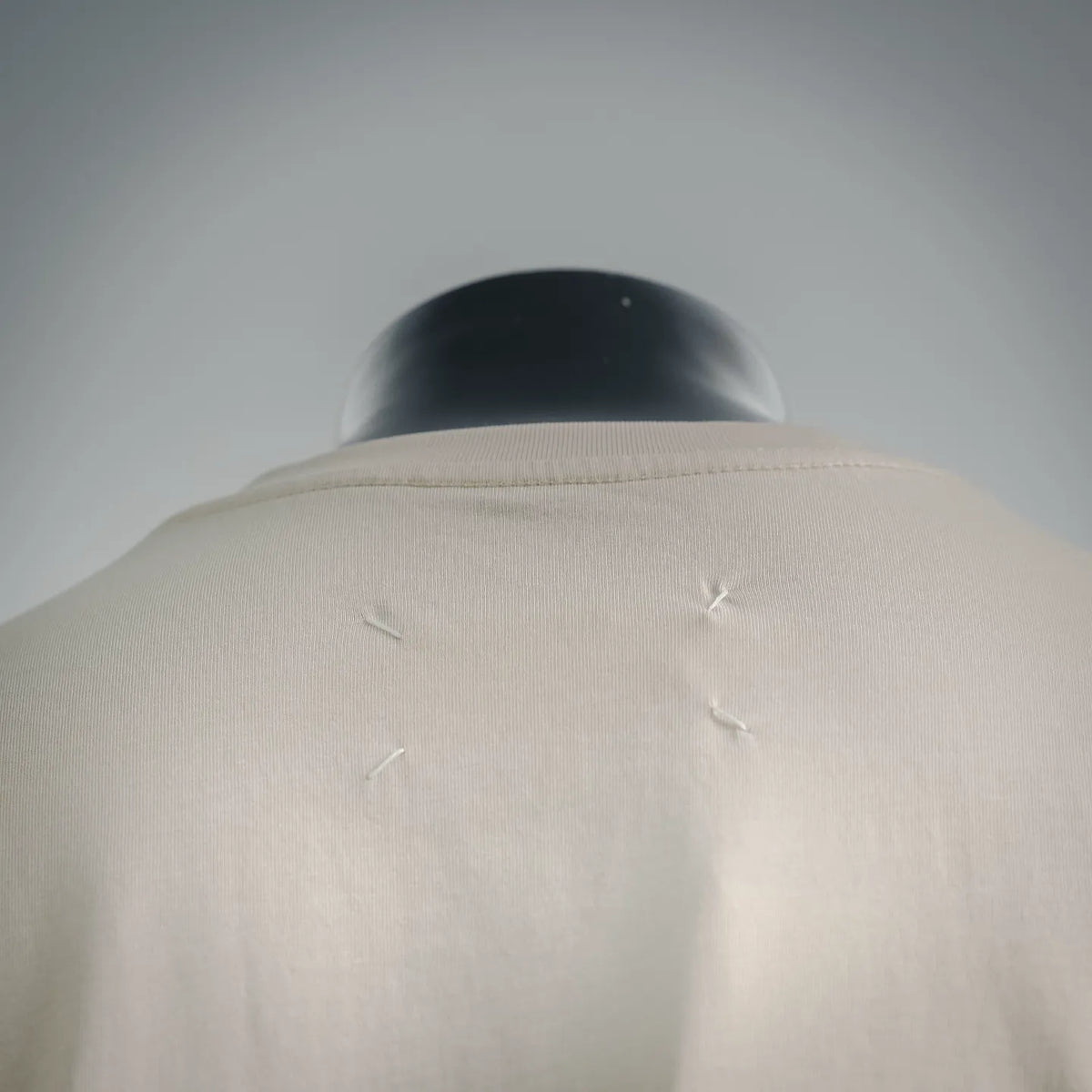 White T-shirt back yoke with small cross-stitch marks