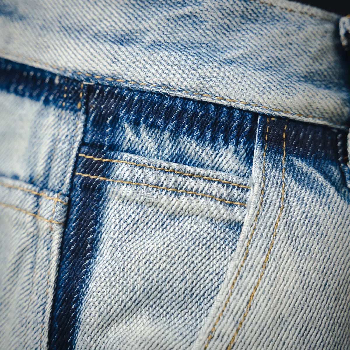 Denim jeans front close-up with button fly, seam lines, and topstitching