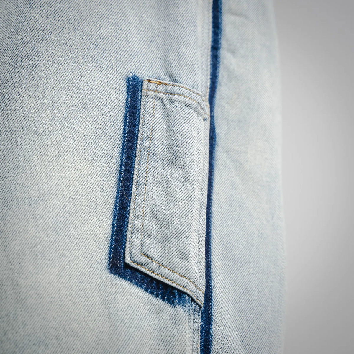 Denim pants front pocket close-up with dark blue stitched outline