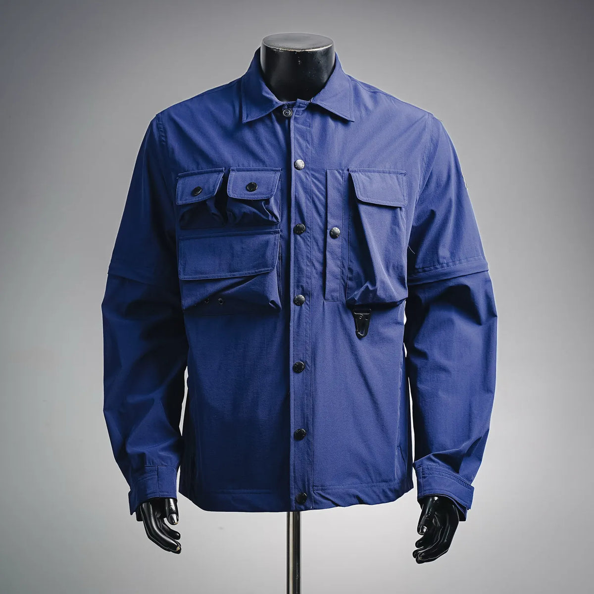 Blue long-sleeve button-up jacket with flap chest pockets and button front