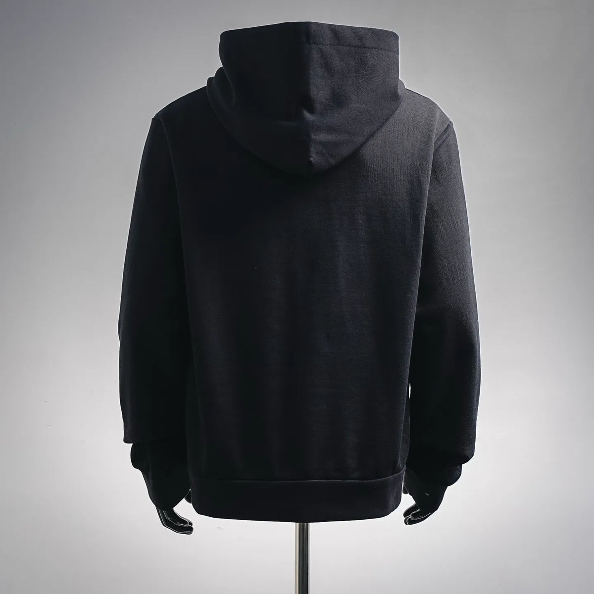Black zip-up hoodie jacket, back view with attached hood.