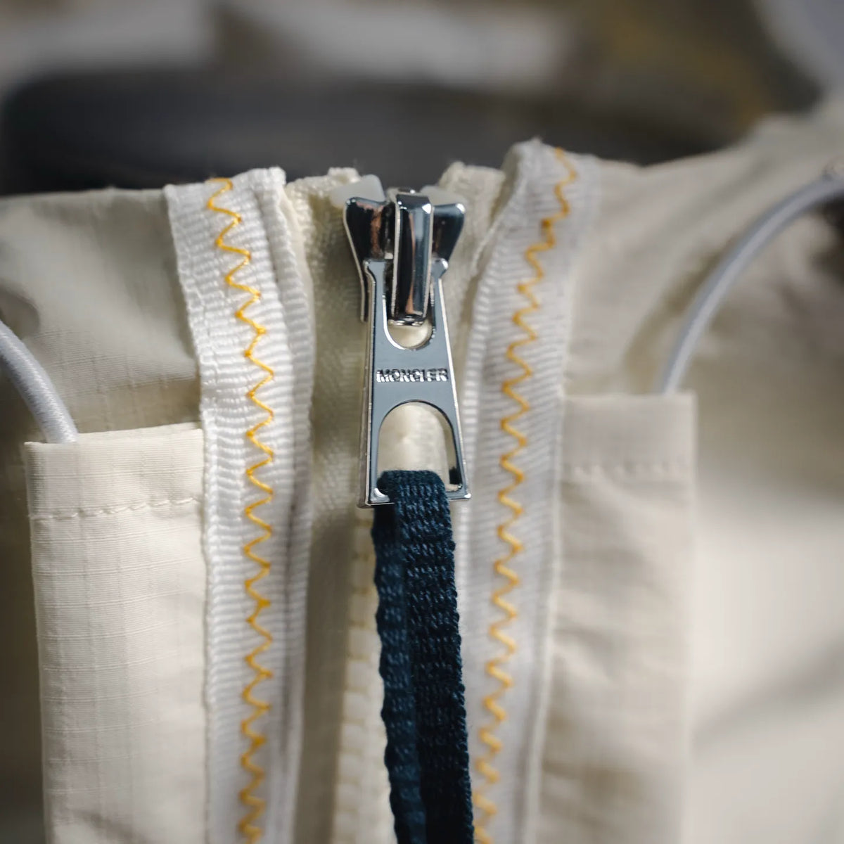Moncler coat zipper with logo pull and yellow contrast stitching