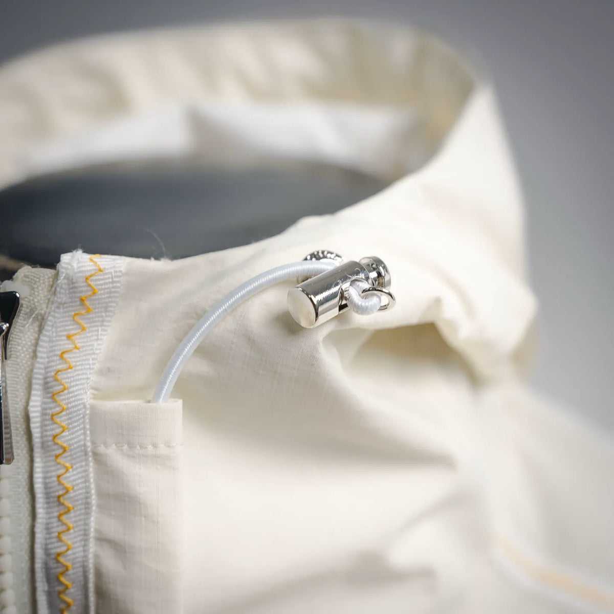 Moncler coat zipper pull with curved metal toggle and white cord