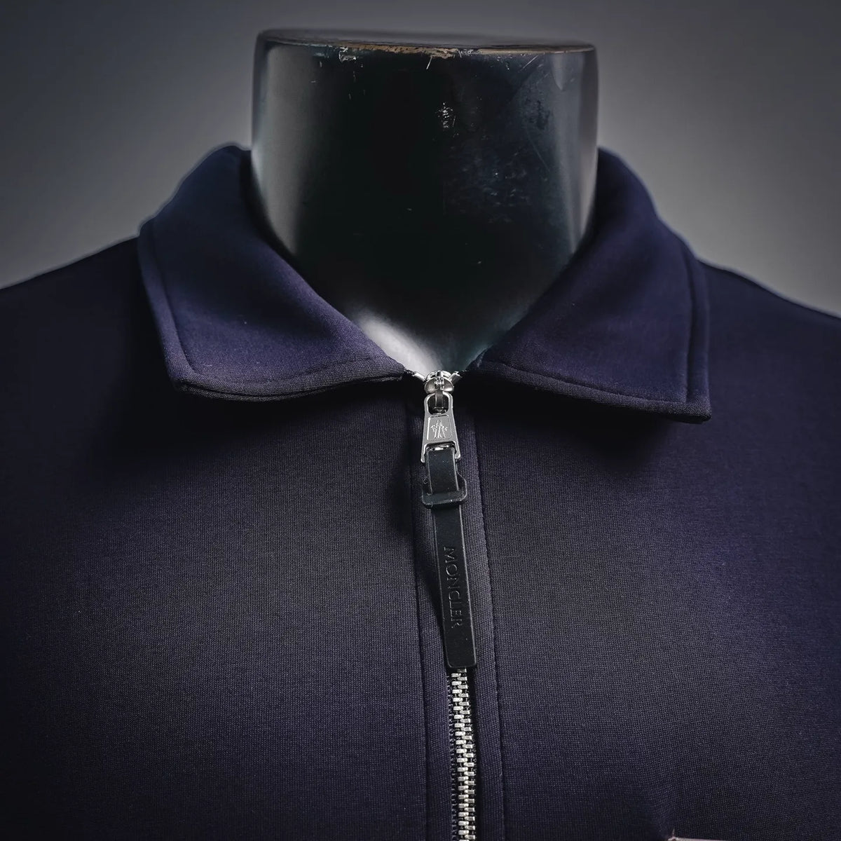 Moncler stand-collar coat with front zipper and dark navy-purple fabric.