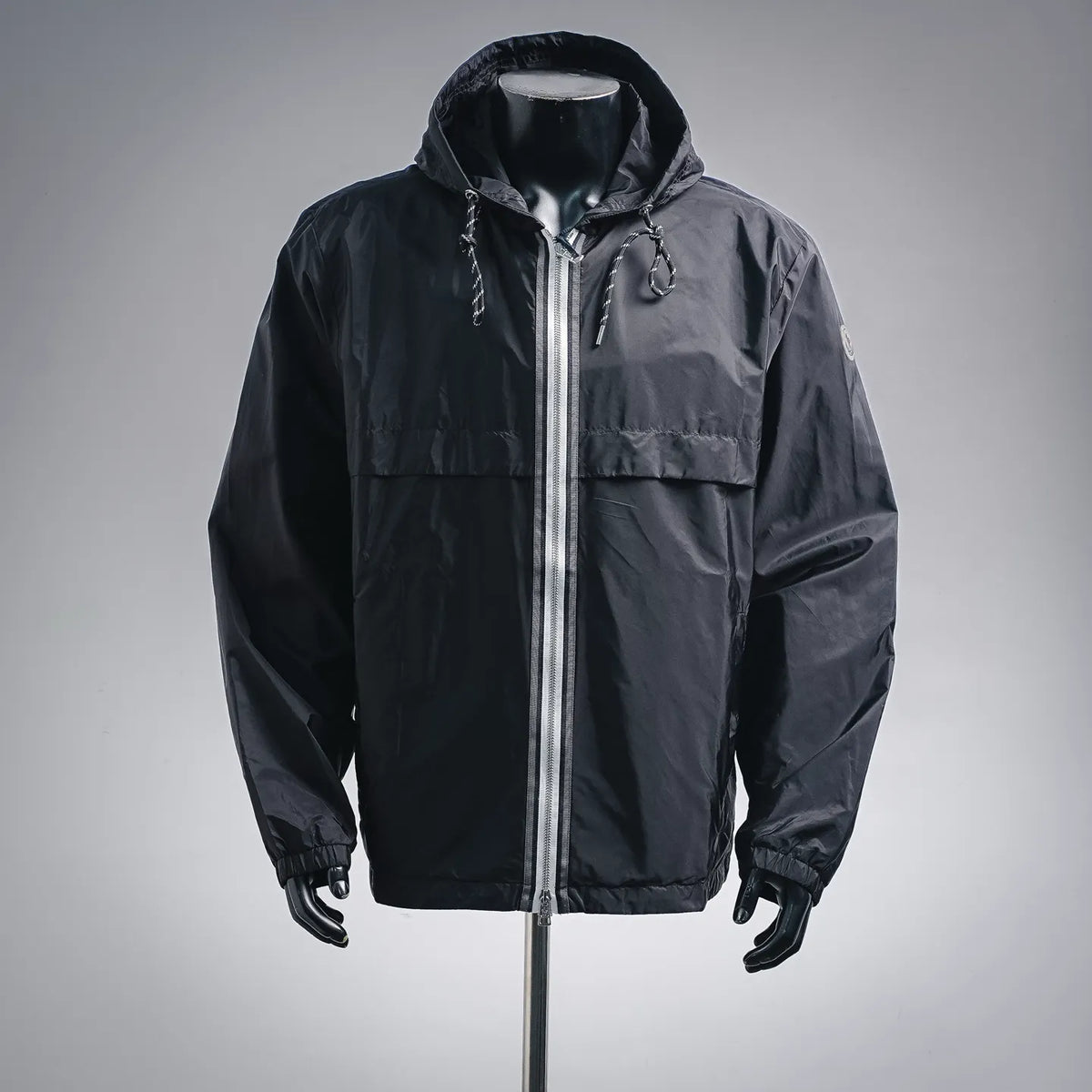 Dark hooded Moncler coat with full-zip front and drawstring toggles