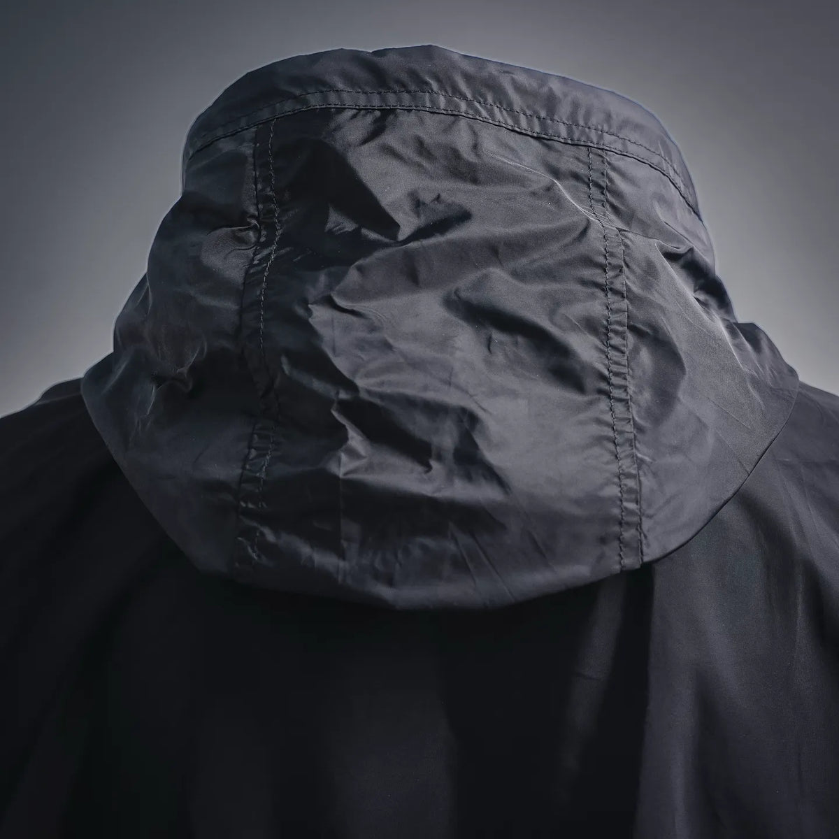 Dark hooded Moncler coat hood with stitched panels and textured fabric