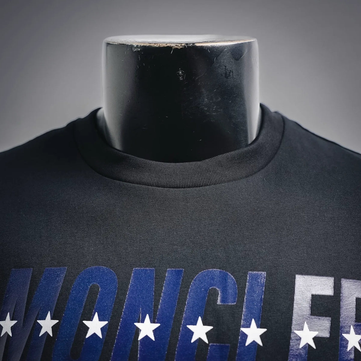 Moncler dark blue T-shirt with large blue-and-white word graphic and star accents