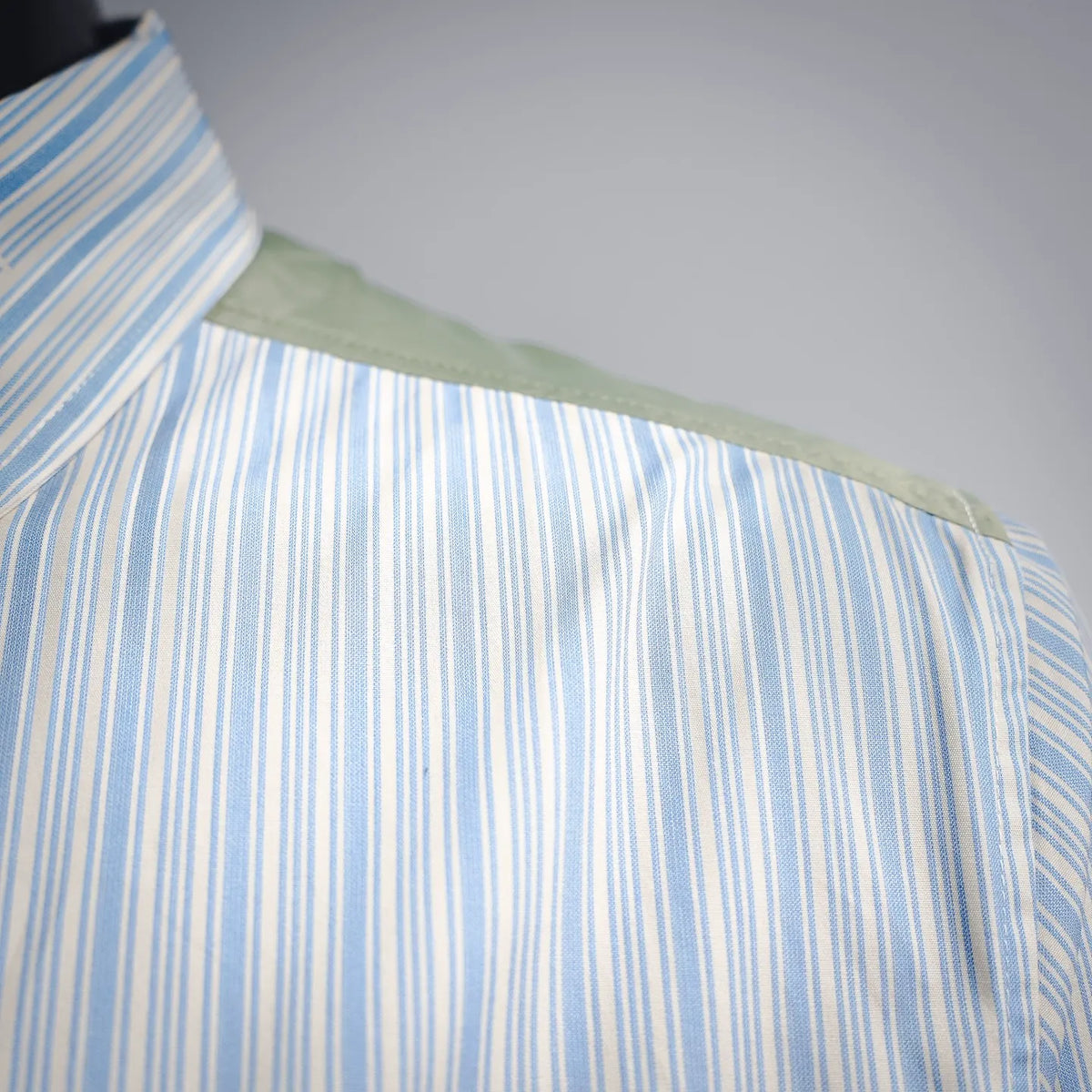 Blue striped shirt-jacket shoulder with green contrast yoke
