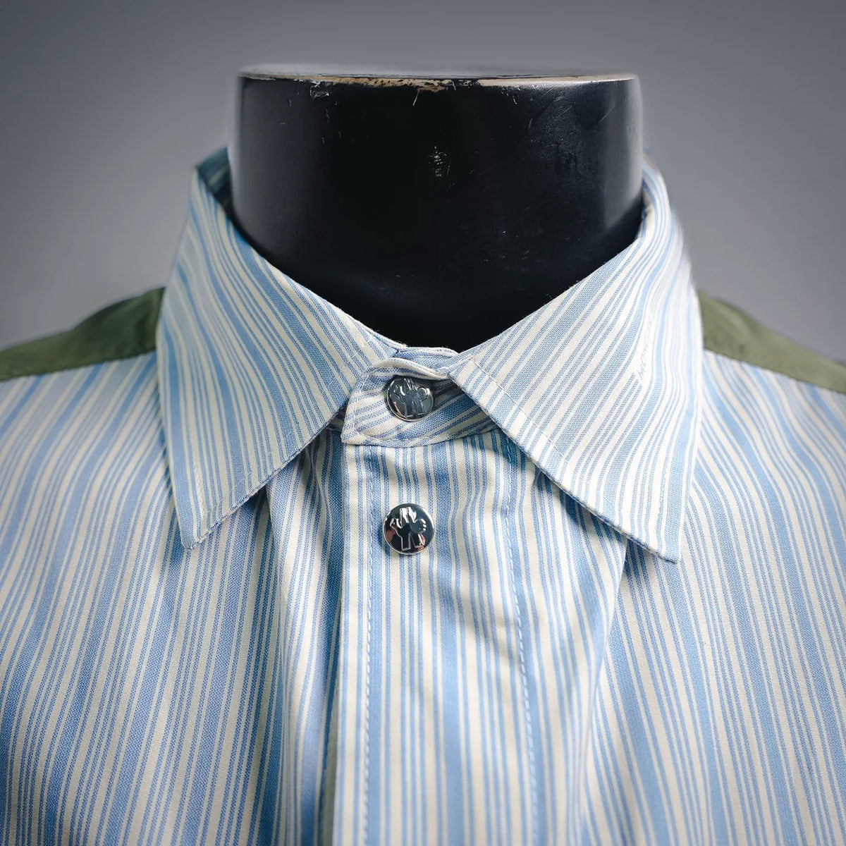 Button-front shirt-jacket with blue vertical stripes and dark round logo buttons