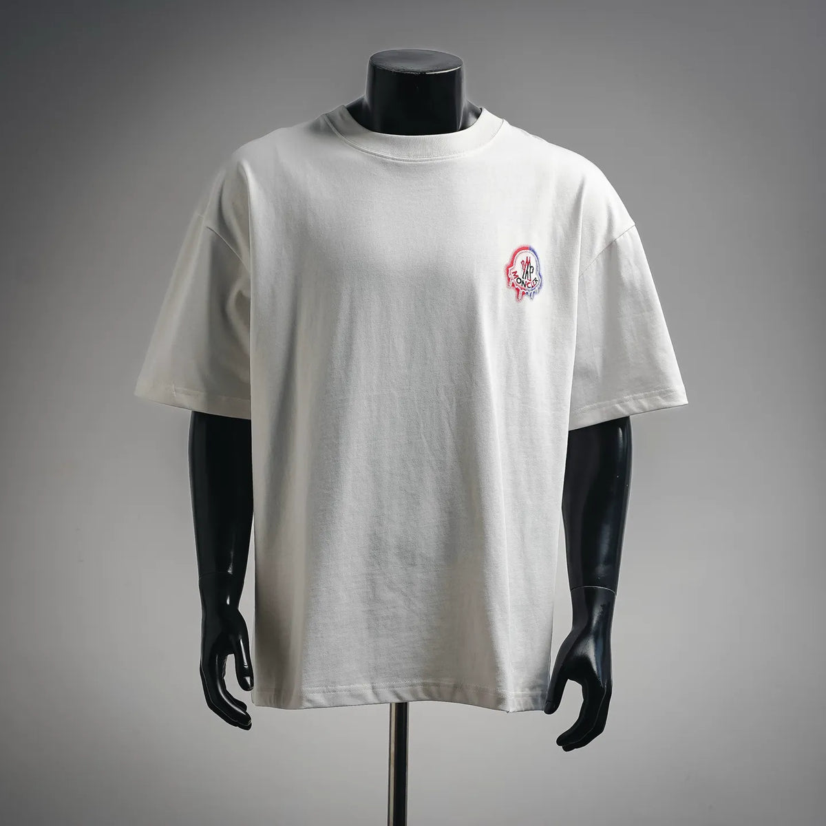 White short-sleeve crewneck T-shirt with small colorful chest logo patch