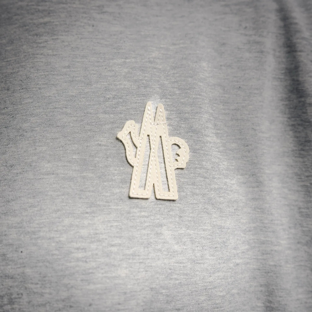 Heather gray T-shirt with small cream embroidered chest logo