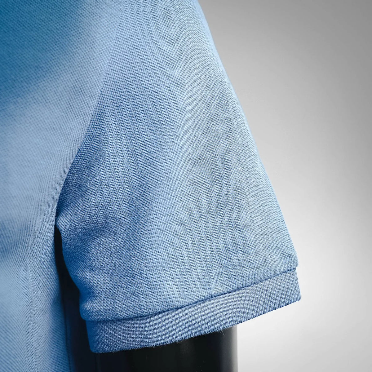 Light blue polo shirt sleeve cuff with stitched hem