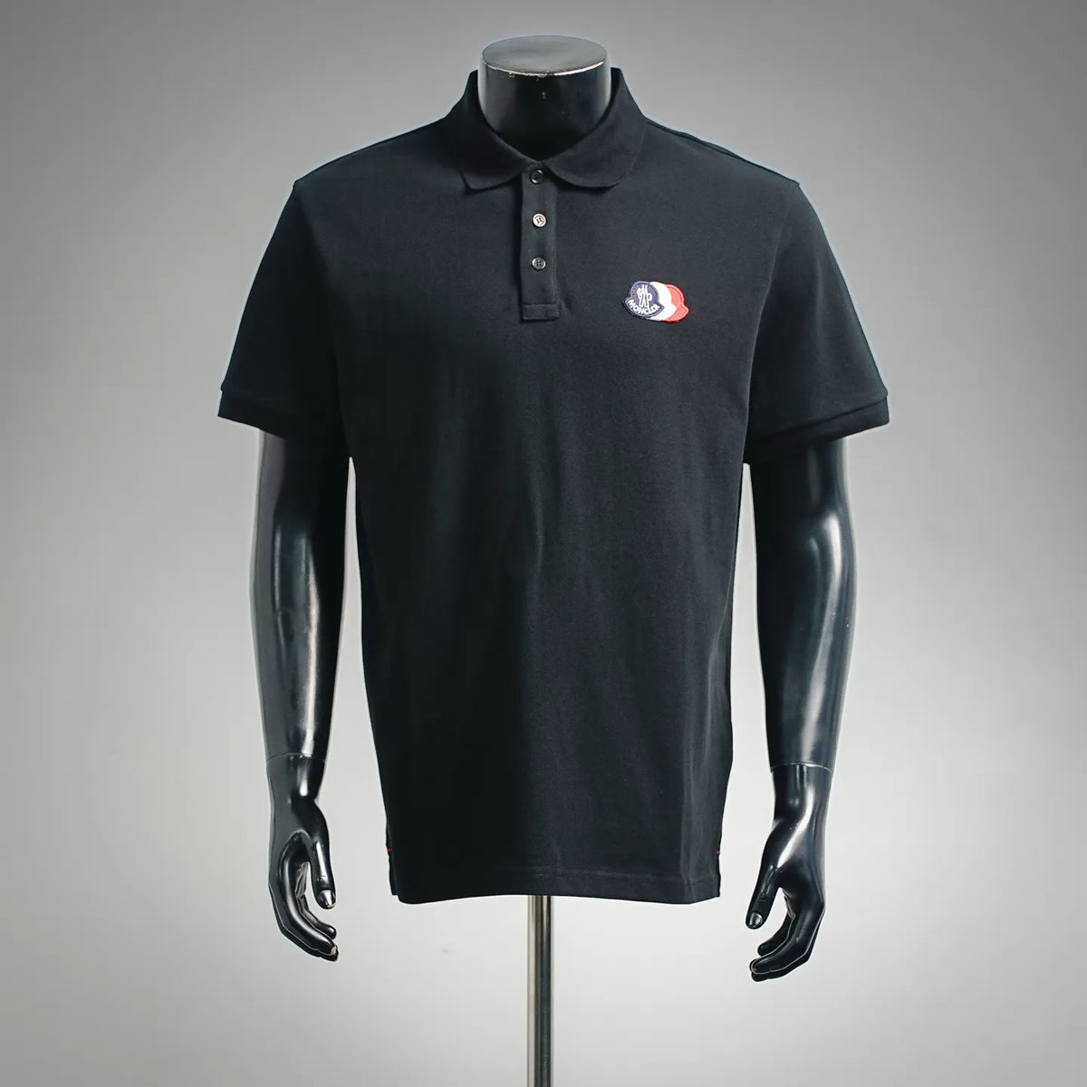 Black short-sleeve polo shirt with button placket and chest logo patch